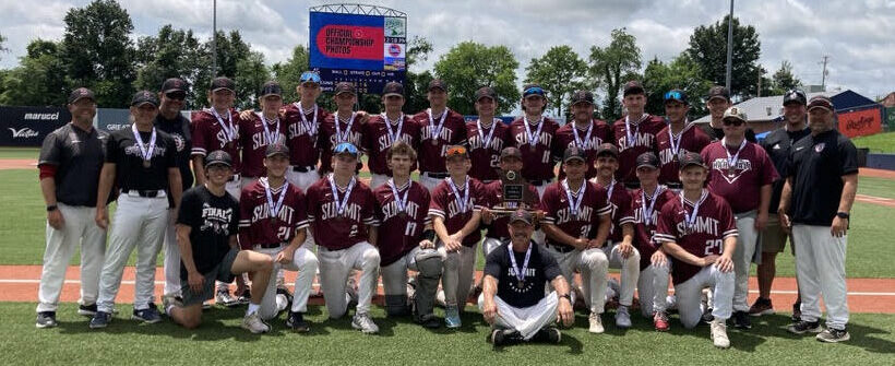 Baseball team posing on field with medals.