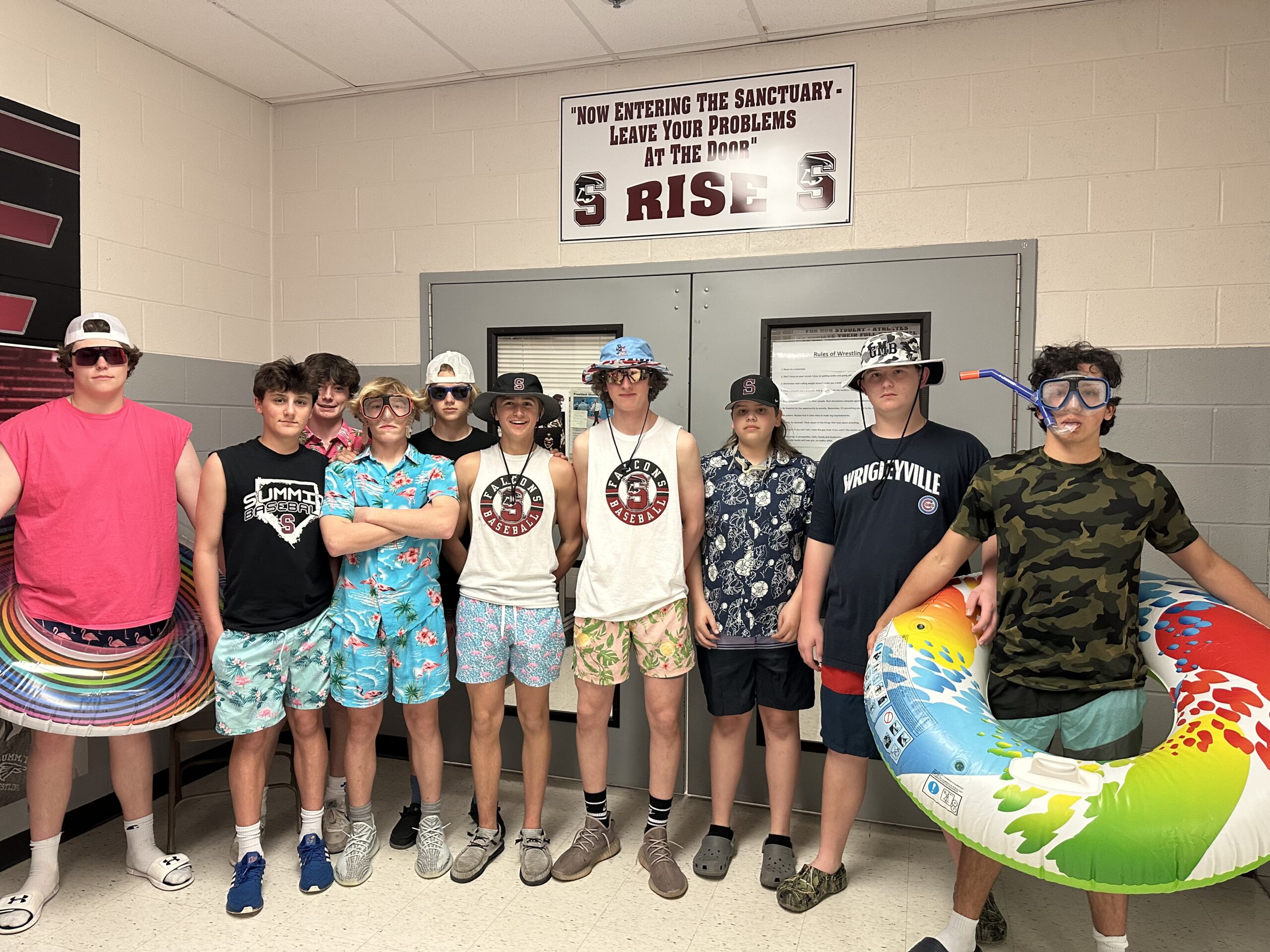 Group of young men posing in a locker room with casual summer attire.