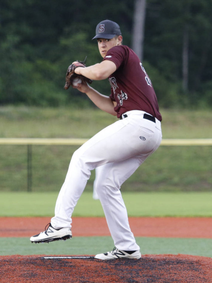 Baseball pitcher preparing to throw a pitch on the mound.