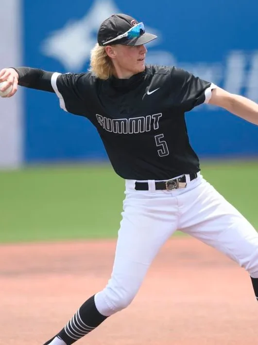 Baseball player pitching during a game on a sunny day.
