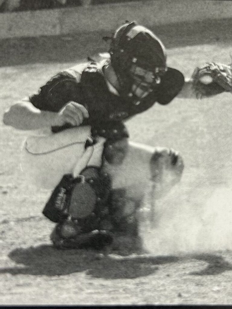 Baseball catcher in action, blocking a base.